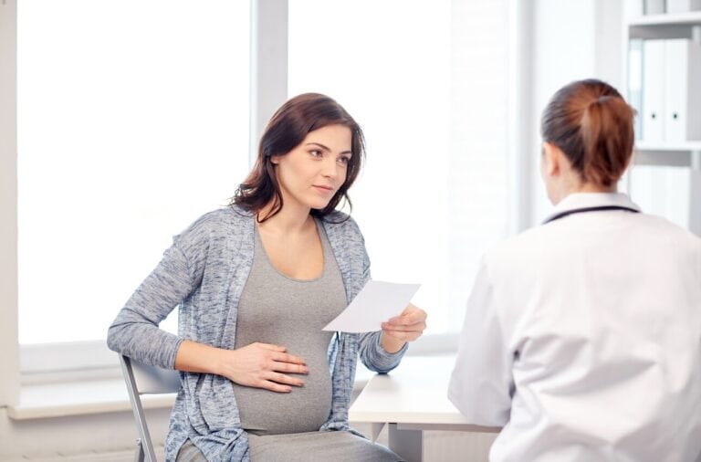 pregnant woman in clinic talking with surgeon