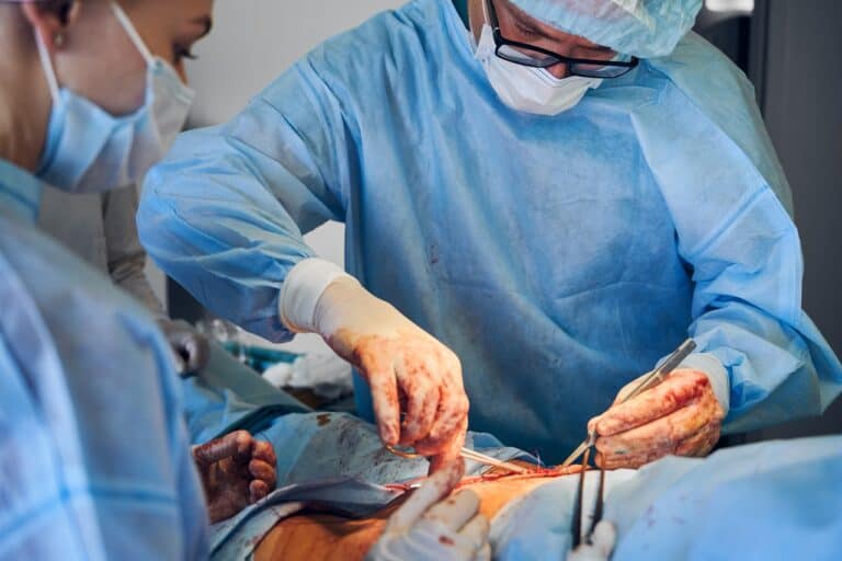 surgeon with assistant doing lipo in abdomen