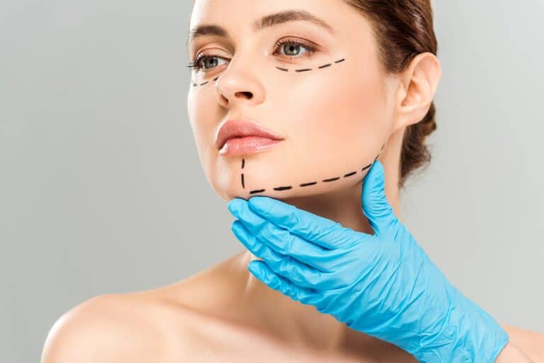 plastic surgeon touching chin and jawline of patient
