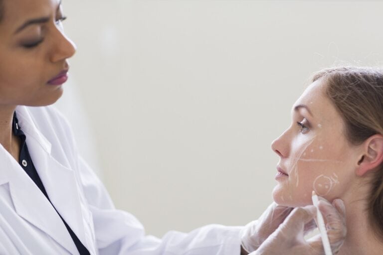 female surgeon marking patient face