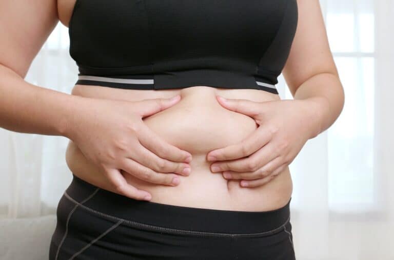 woman squeezing belly with two hands