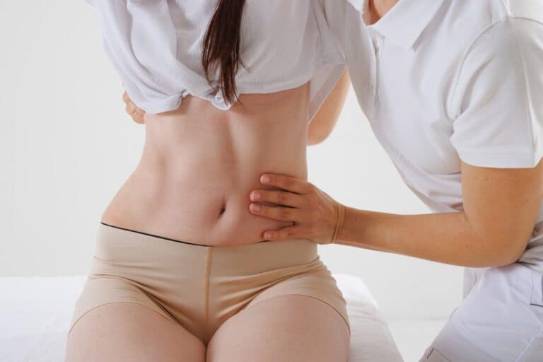 surgeon checks woman's midsection