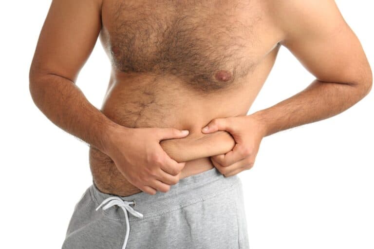 overweight man squeezing his flanks
