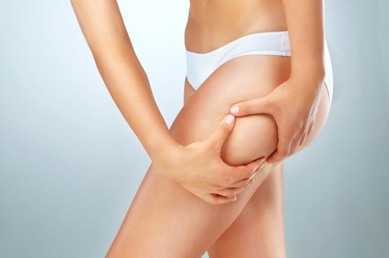 woman in white underwear squeezing her outer thigh