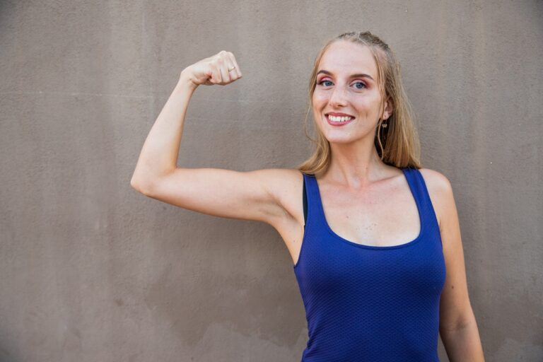 blonde woman in blue sando flexing arm