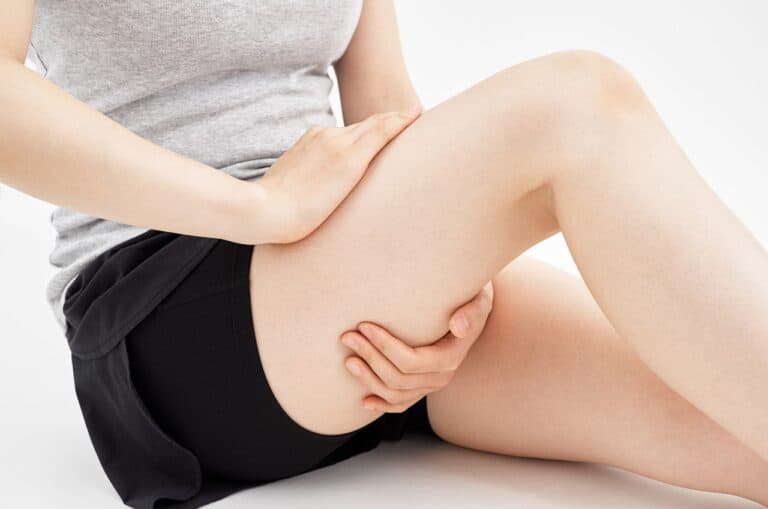 woman sitting touching thigh