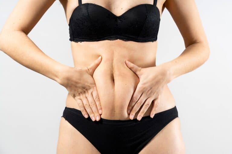 woman squeezing her belly fat